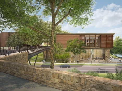 Architectural rendering of a modern building with extensive use of glass and wood, featuring a pedestrian bridge leading to its entrance. The building is surrounded by lush greenery, a body of water, and has people walking around, indicating a lively atmosphere