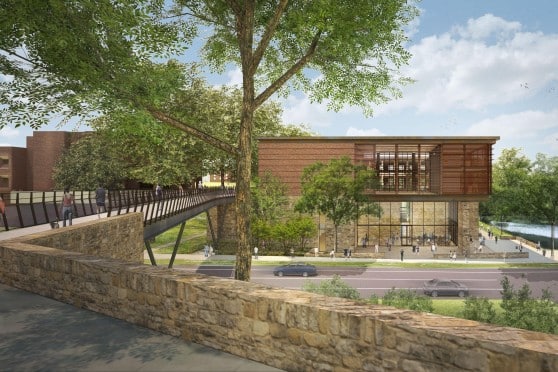 Architectural rendering of a modern building with extensive use of glass and wood, featuring a pedestrian bridge leading to its entrance. The building is surrounded by lush greenery, a body of water, and has people walking around, indicating a lively atmosphere