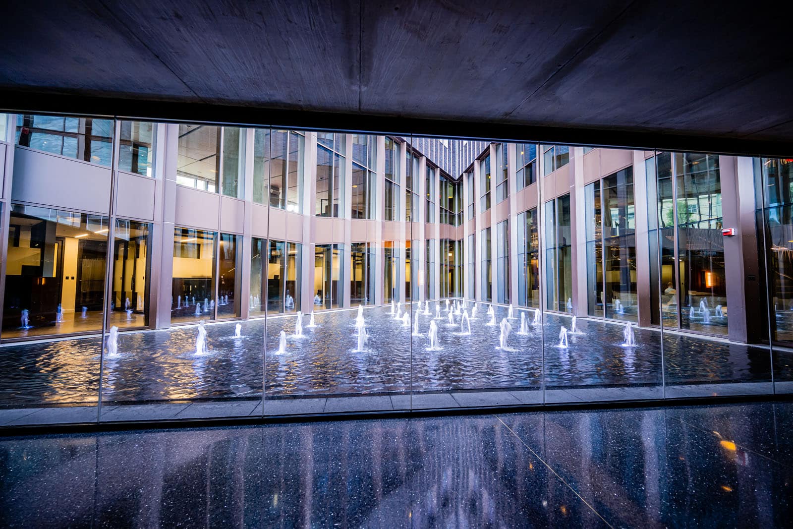 A large window overlooking a triangular shaper water feature, with many smaller fountains.