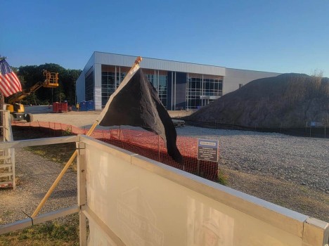 A black pennant flag in front of a construction site.