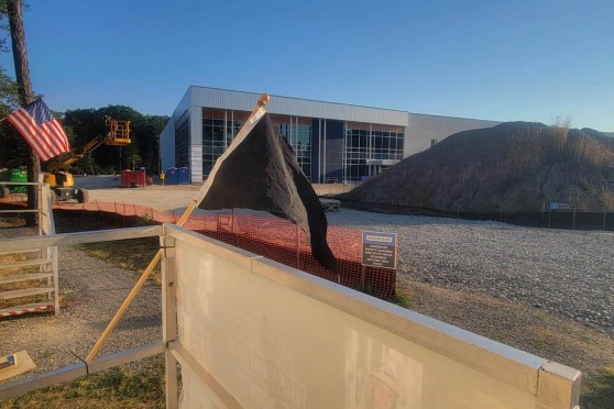 A black pennant flag in front of a construction site.