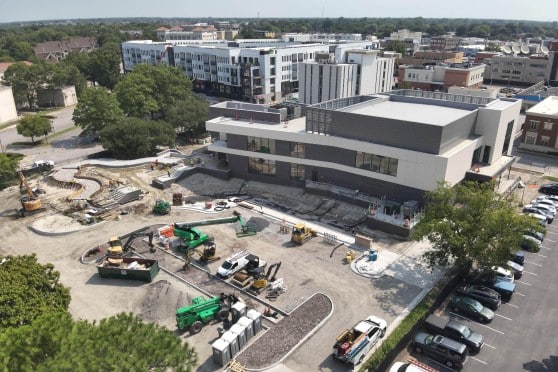 Aerial view of Chrysler Museum. Gray building with large parking lot of gravel with construction equipment parked.