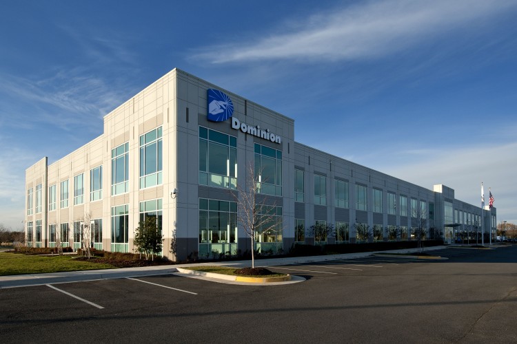 Two story building with glass windows and parking lot