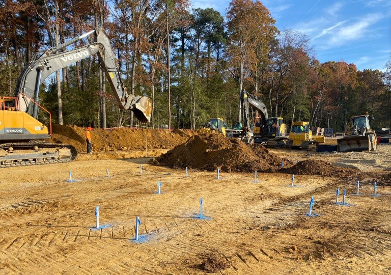 bobcats and backhoes working in clay sitepad